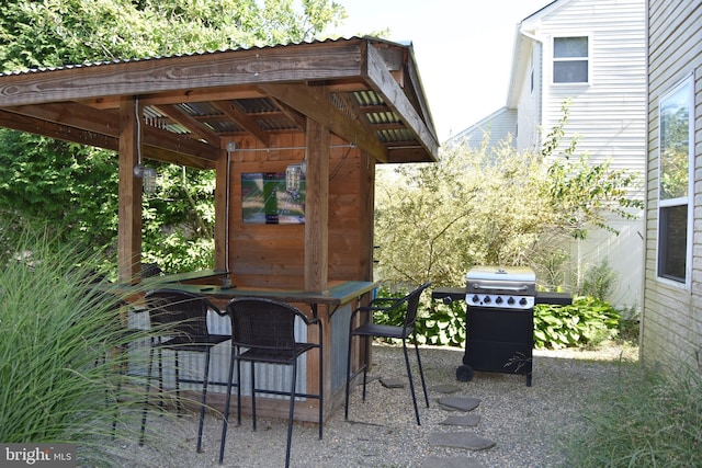 view of patio with outdoor dry bar and grilling area