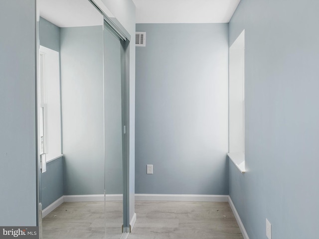 unfurnished bedroom with baseboards, visible vents, and wood finished floors