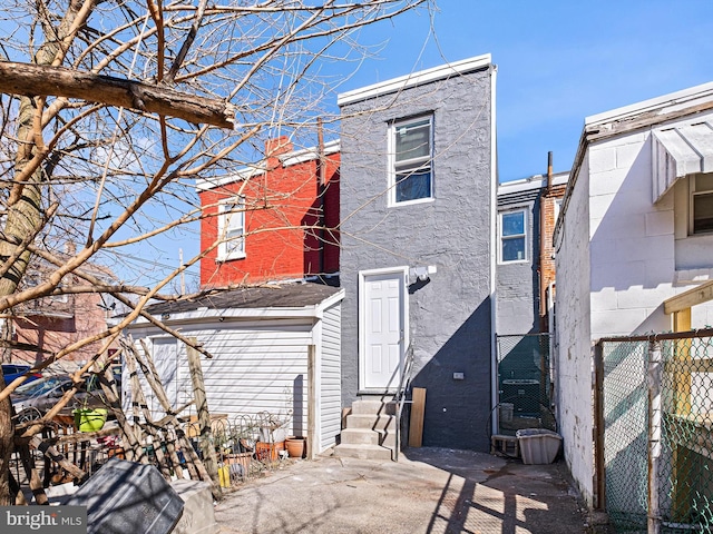 rear view of property with entry steps and fence