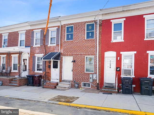 townhome / multi-family property featuring entry steps, cooling unit, and brick siding