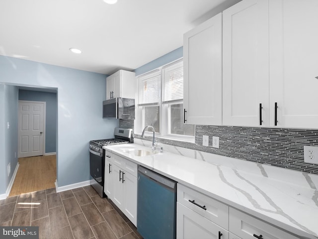 kitchen featuring stainless steel appliances, backsplash, a sink, and white cabinets