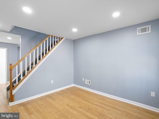 finished below grade area with recessed lighting, visible vents, wood finished floors, baseboards, and stairs