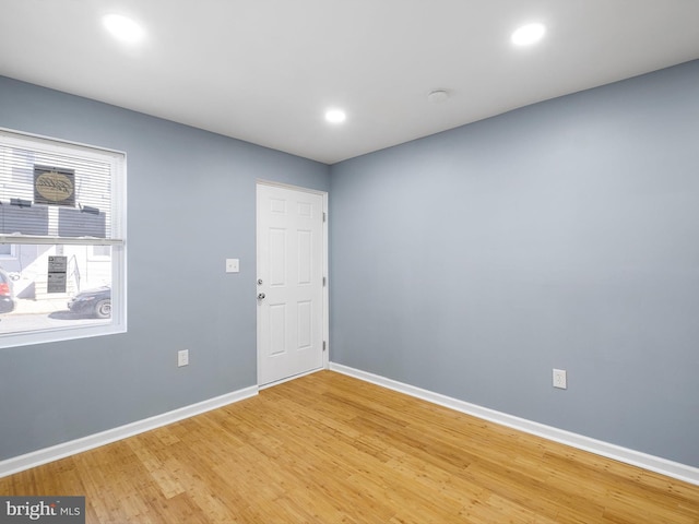 spare room with recessed lighting, light wood-style flooring, and baseboards