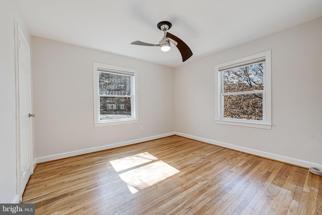 unfurnished bedroom with multiple windows, light wood-style flooring, and baseboards