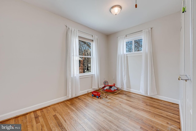 spare room with hardwood / wood-style floors and baseboards