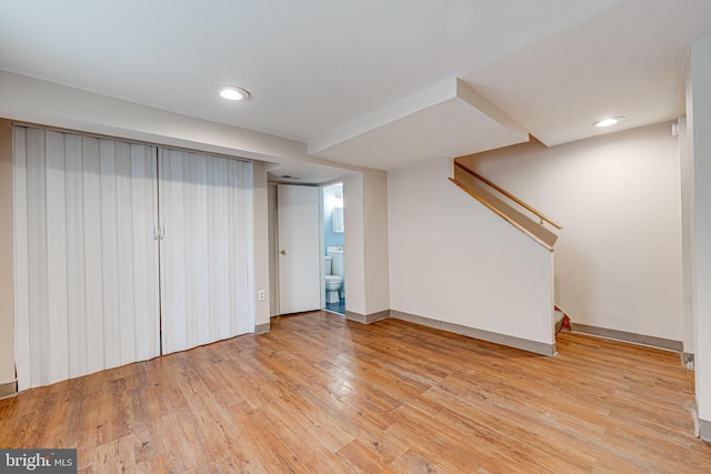 finished below grade area featuring stairs, wood-type flooring, baseboards, and recessed lighting