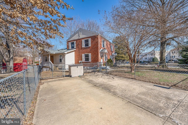 view of front facade featuring a fenced front yard, a gate, and brick siding