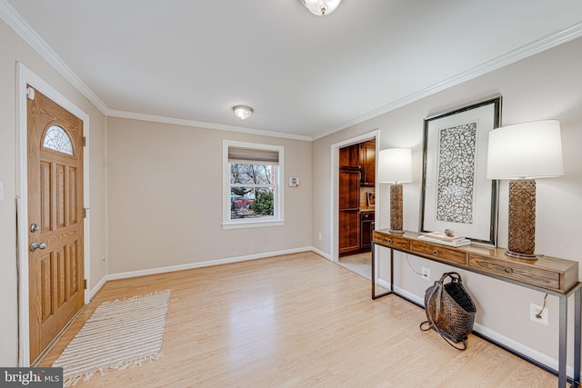 foyer with ornamental molding, light wood-style flooring, and baseboards