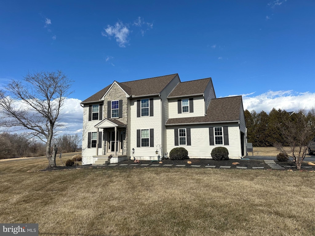 colonial house with a shingled roof and a front lawn