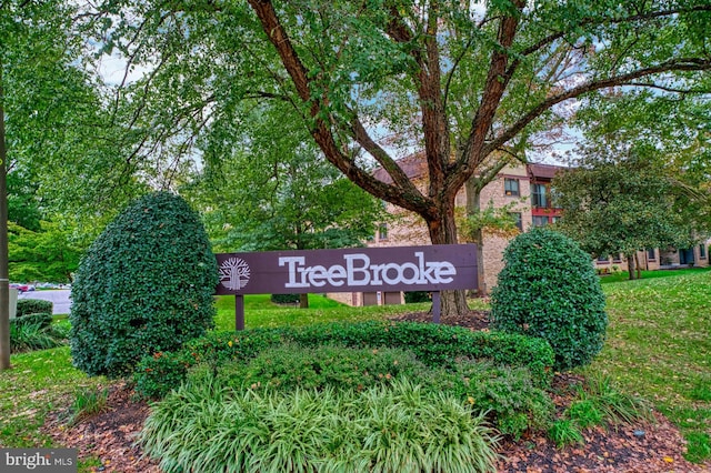 community / neighborhood sign featuring a lawn