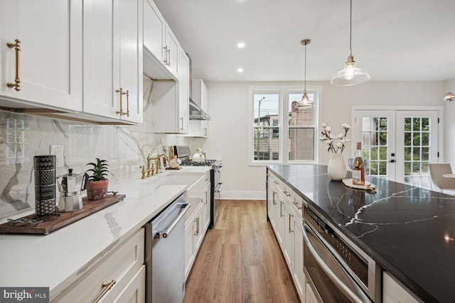 kitchen featuring french doors, light wood finished floors, stainless steel appliances, backsplash, and light stone countertops