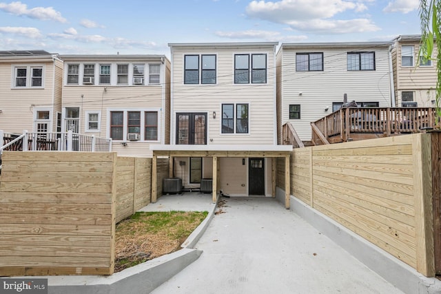 rear view of house featuring cooling unit, fence, central AC unit, and a patio