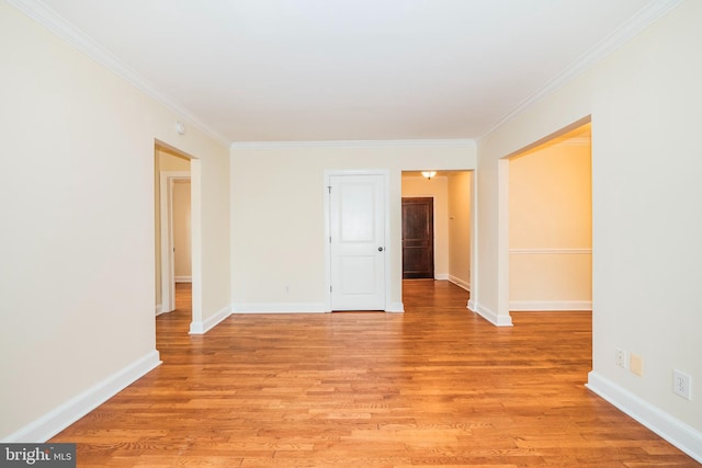 unfurnished room featuring light wood-type flooring, crown molding, and baseboards