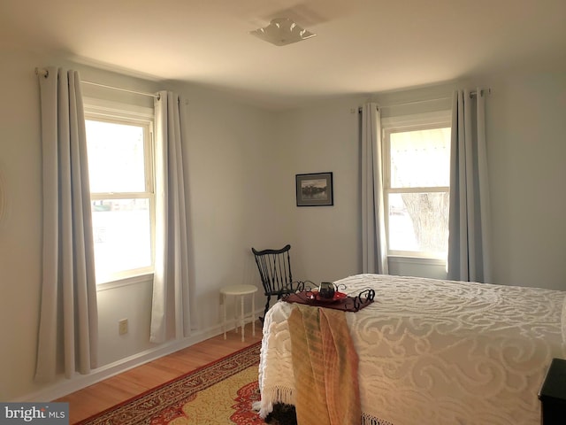 bedroom with light wood-style flooring and multiple windows