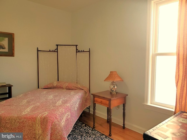 bedroom with baseboards and wood finished floors