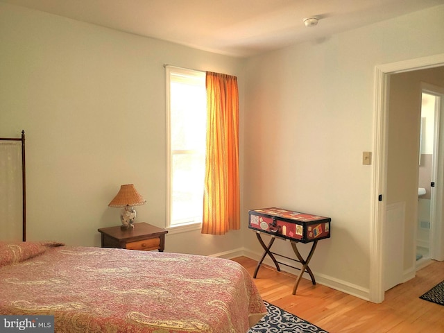 bedroom with light wood finished floors and baseboards