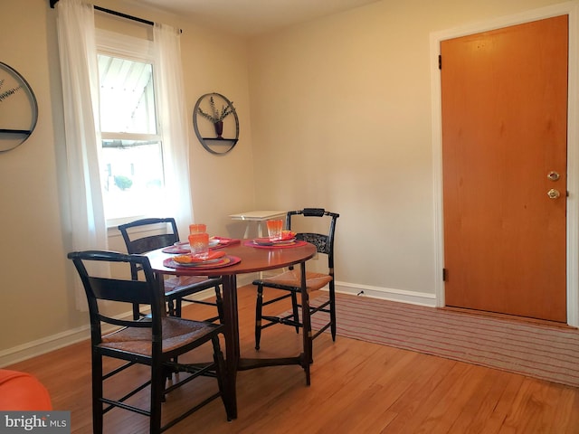 dining area featuring baseboards and light wood-style floors