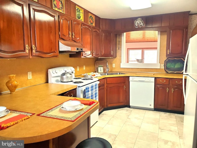 kitchen featuring white appliances, under cabinet range hood, light countertops, and a sink