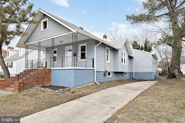 bungalow-style house with a porch and a chimney