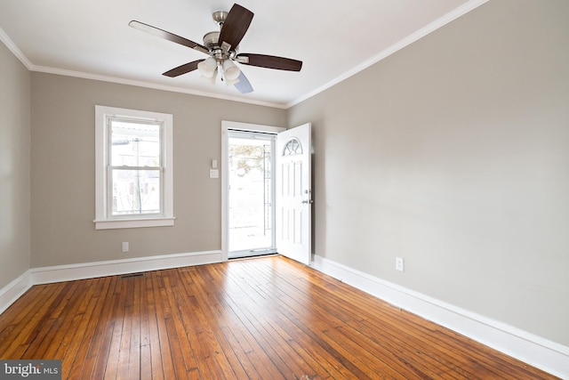 unfurnished room featuring hardwood / wood-style flooring, visible vents, baseboards, and ornamental molding