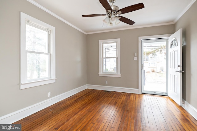 spare room featuring hardwood / wood-style flooring, ceiling fan, baseboards, and crown molding