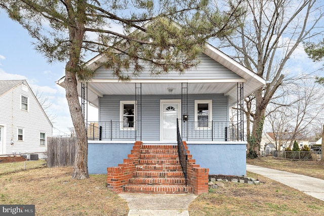 bungalow-style house featuring covered porch and fence