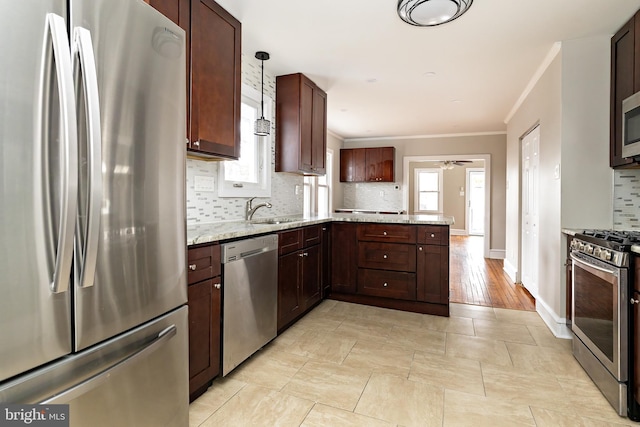 kitchen featuring tasteful backsplash, a peninsula, stainless steel appliances, crown molding, and a sink