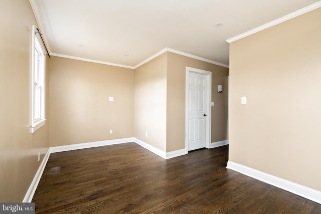 empty room featuring ornamental molding, dark wood-style flooring, and baseboards