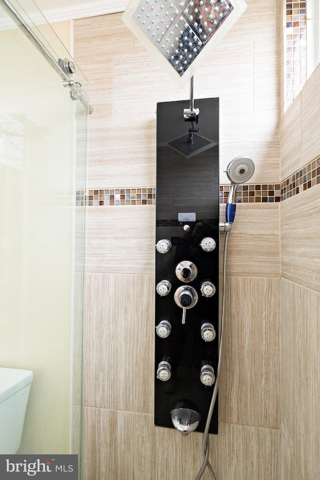 full bathroom featuring toilet and tiled shower