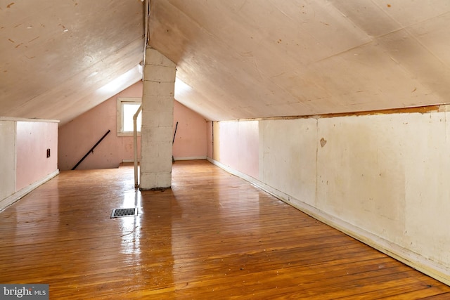 bonus room featuring lofted ceiling, wood-type flooring, and visible vents