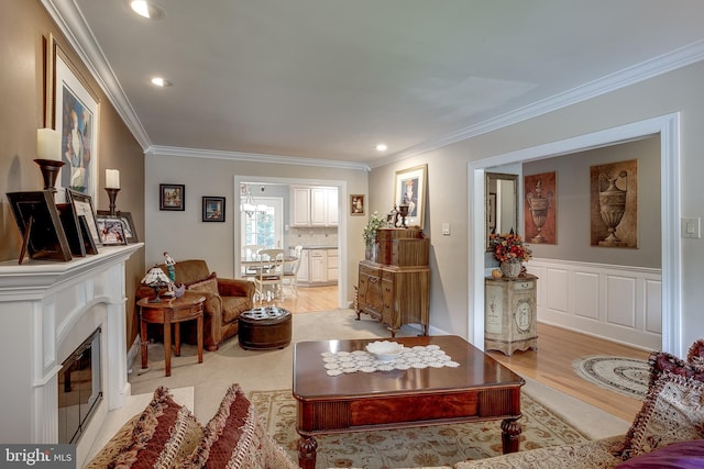 living area featuring ornamental molding, a fireplace, light wood-style flooring, and recessed lighting