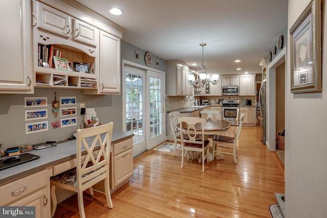 kitchen with stainless steel appliances, light wood-style floors, french doors, backsplash, and built in study area