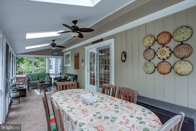 dining space featuring a ceiling fan, vaulted ceiling with skylight, and crown molding