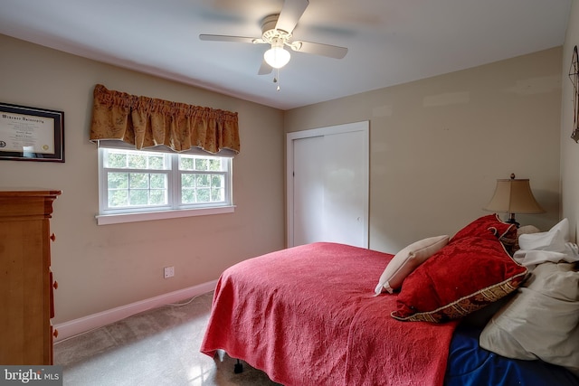 carpeted bedroom with a ceiling fan, a closet, and baseboards