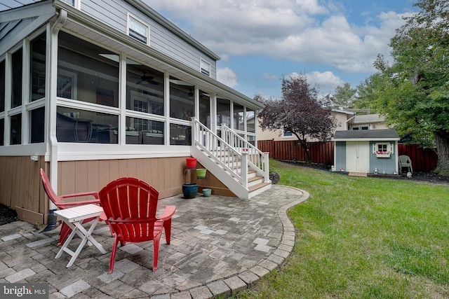 back of house featuring a sunroom, a patio, a storage unit, and fence