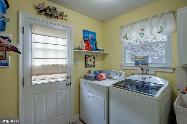 washroom featuring laundry area, separate washer and dryer, and a sink