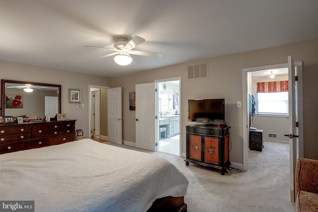 bedroom featuring visible vents, ensuite bath, light carpet, and baseboards