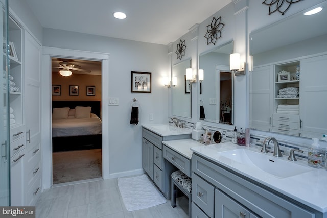 ensuite bathroom with connected bathroom, vanity, baseboards, a ceiling fan, and tasteful backsplash