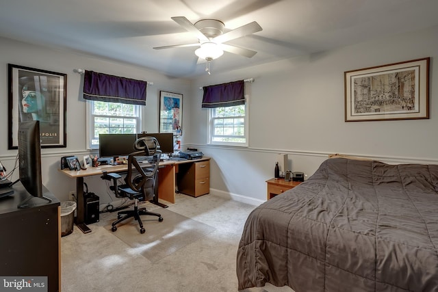 carpeted bedroom with ceiling fan and baseboards