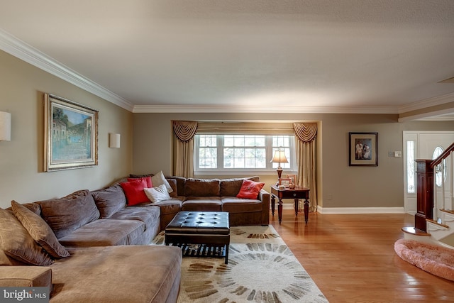 living room with light wood-style floors, baseboards, stairway, and ornamental molding