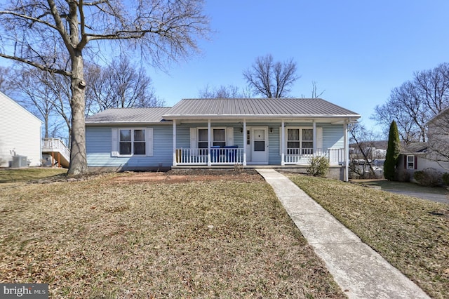 view of front of house with metal roof, a porch, a front lawn, and central air condition unit