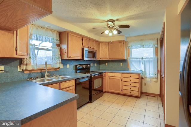 kitchen featuring a wealth of natural light, light tile patterned flooring, a sink, and black appliances