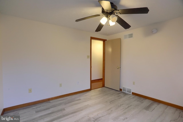 unfurnished room featuring light wood-type flooring, visible vents, and baseboards