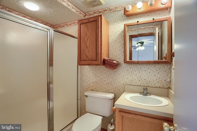 bathroom with wallpapered walls, a stall shower, visible vents, toilet, and vanity