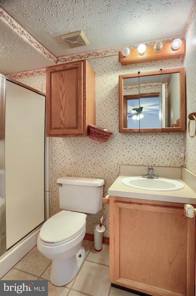 bathroom featuring wallpapered walls, a shower stall, visible vents, and tile patterned floors