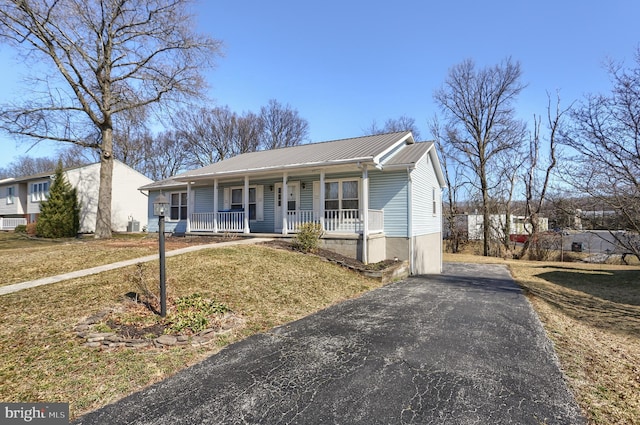 view of front of house with metal roof, a porch, and aphalt driveway