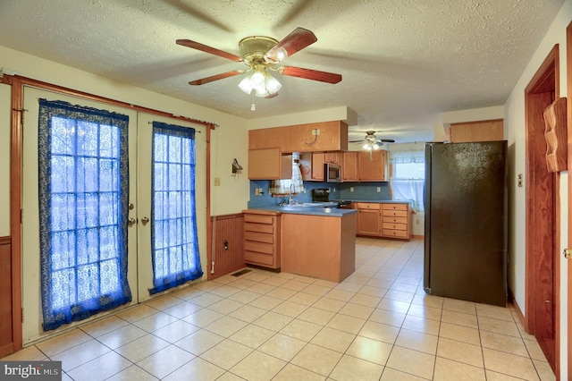 kitchen featuring stainless steel microwave, freestanding refrigerator, a peninsula, french doors, and range with electric stovetop