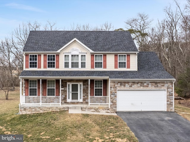 view of front of property featuring aphalt driveway, roof with shingles, covered porch, an attached garage, and a front lawn