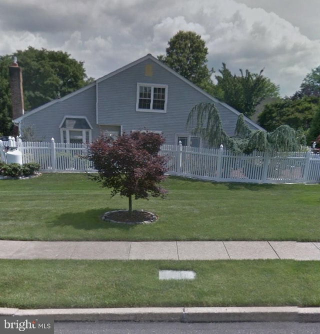 view of side of property with a yard and fence