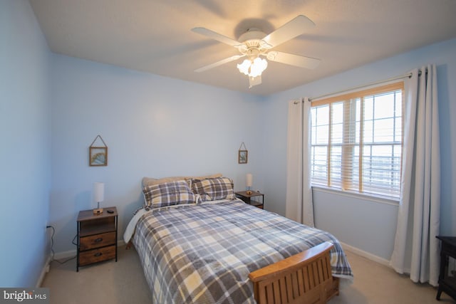 bedroom featuring baseboards, ceiling fan, and light colored carpet